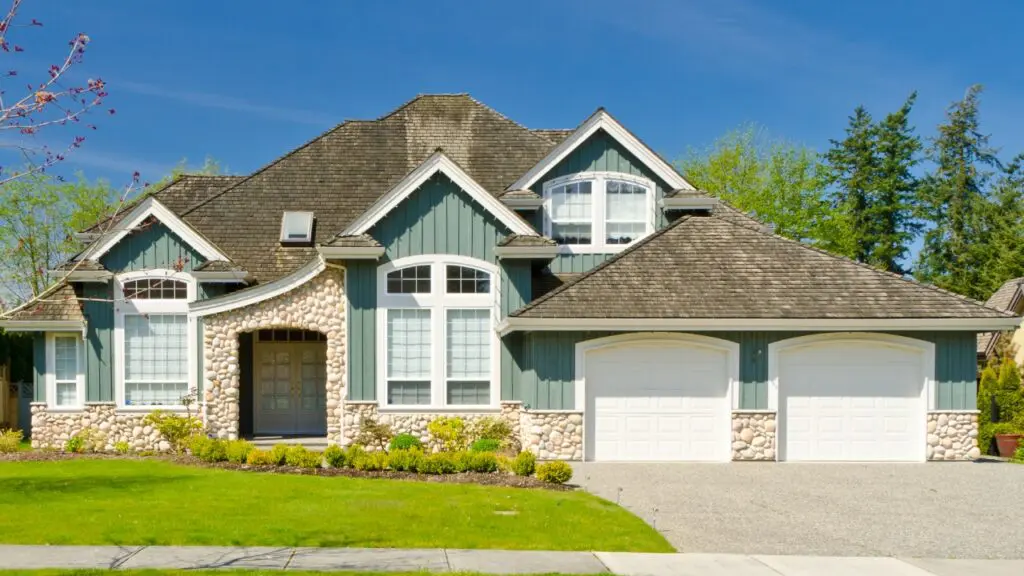 A house with a driveway and lawn in front of it.
