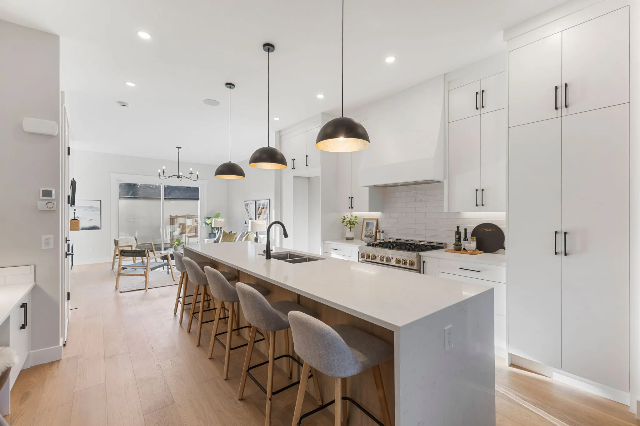 A kitchen with white cabinets and wooden floors