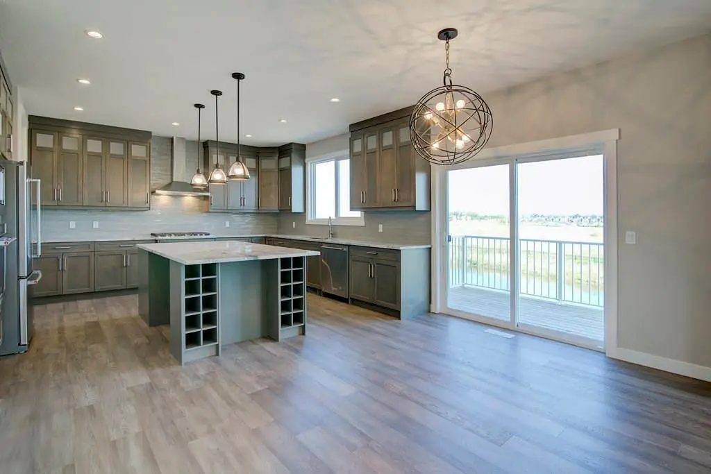 A kitchen with a large window and wooden floors