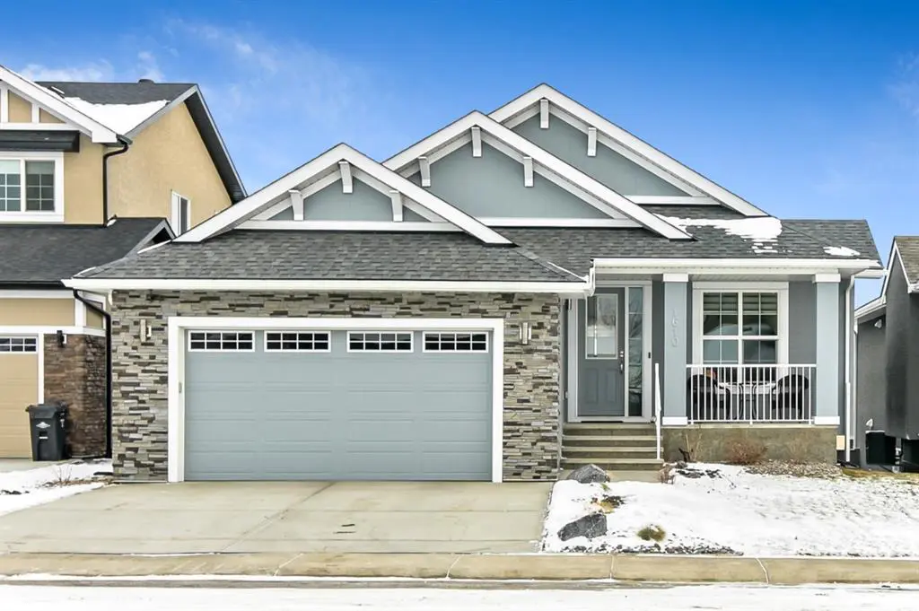A house with two garage doors and snow on the ground.