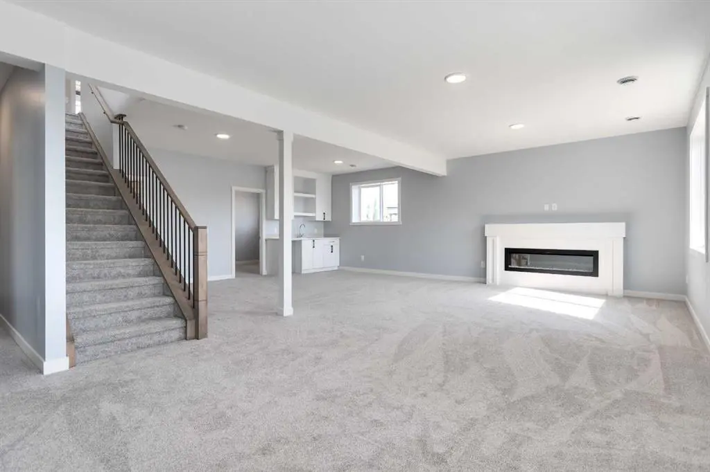 A large open room with stairs leading to the basement.