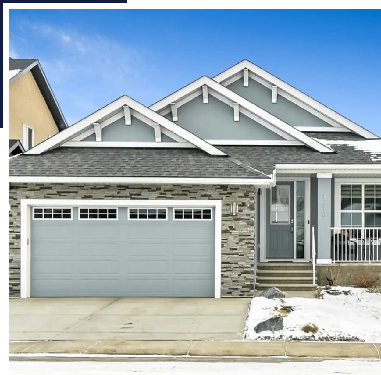 home_-_3rd_section-21.png (1) A house with a garage and snow on the ground.